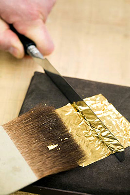 Tagliare la foglia oro con il coltello da doratore